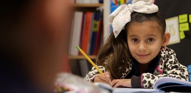 First grade girl holding pencil