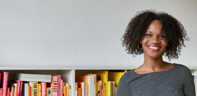 Publisher standing in front of a bookcase